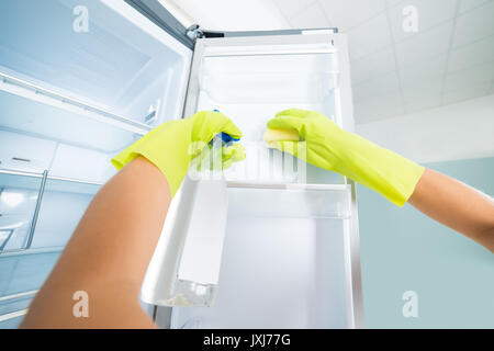 Woman Hand Wearing Gloves Cleaning The Empty Refrigerator With Spray Bottle And Sponge Stock Photo