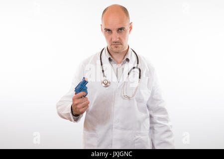 Intense doctor holding a toy handgun as he stares at the camera with an expressionless face over white Stock Photo