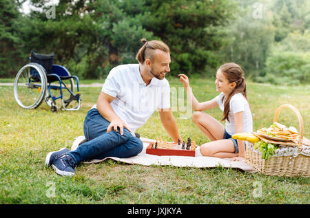 Smiling girl asking her father about chess figures Stock Photo