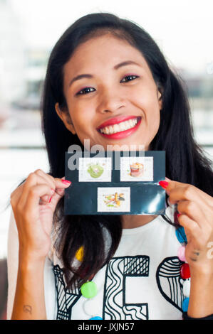 Young Asian woman holding set of lao stamps depicting betel nut items Stock Photo