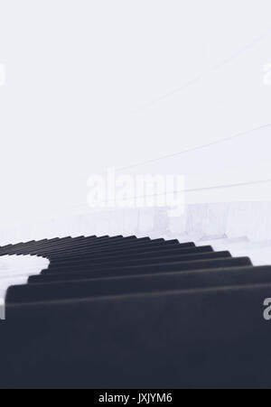 Conceptual black and white image with spiral stairs going down and a strong light at the end of it Stock Photo