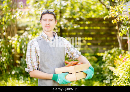 Man in gloves holding carrots Stock Photo