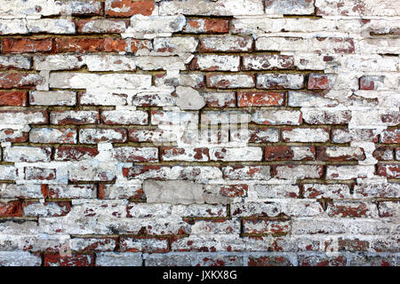 Rough ed brick wall, straight on with white plaster crumbling Stock Photo