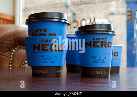 Close up of Cafe Caffe Nero paper disposable coffee cups cup takeout takeaway on table in shop store England UK United Kingdom GB Great Britain Stock Photo