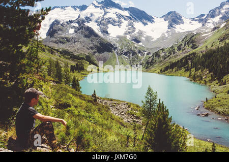 Traveler Man relaxing with serene view mountains and lake landscape Travel Lifestyle hiking concept summer vacations outdoor Stock Photo