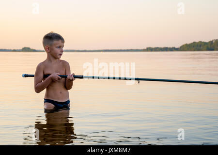 Boy fishing waist deep in water Stock Photo - Alamy