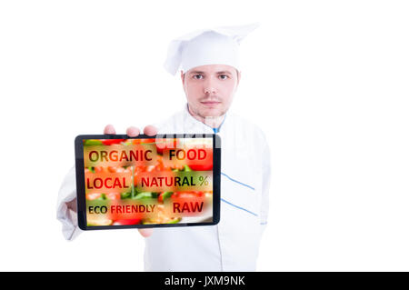 Chef showing a digital tablet with vegan food on white background as organic and eco food concept Stock Photo