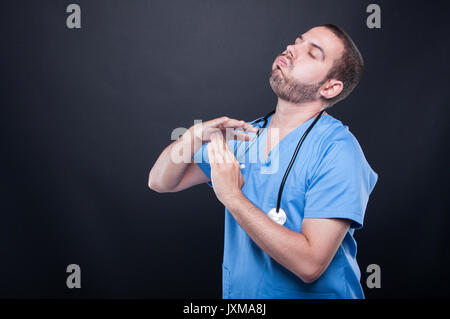 Tired doctor wearing scrubs with stethoscope making time out gesture on black background with copy text space Stock Photo