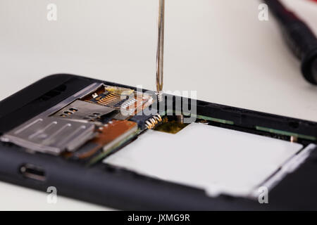 Close-up Of Broken Mobile Phone With Screwdriver Stock Photo