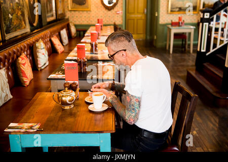 Quirky man eating in bar and restaurant, Bournemouth, England Stock Photo