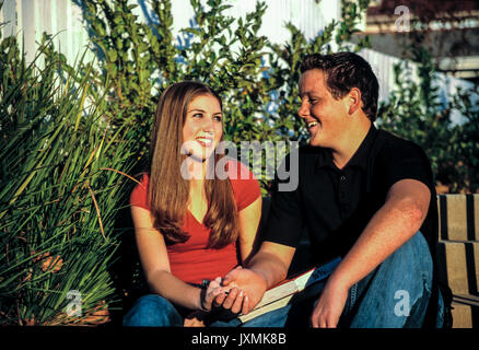 Childhood young person people Young teenage  couple smiling at each other  Sitting on steps in front yard of school Wholesome innocent © Myrleen Pearson Stock Photo