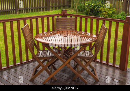 Rain soaked garden table & chairs on a wet day in the UK when summer is over. Easier than photographing a sunny day in the UK. Stock Photo
