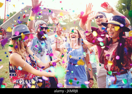 Young adult friends throwing confetti at festival Stock Photo