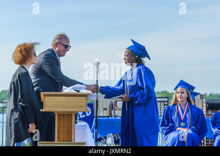Student shaking hands with senior man at graduation ceremony Stock Photo