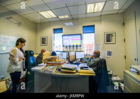 Three office workers at desks in office Stock Photo