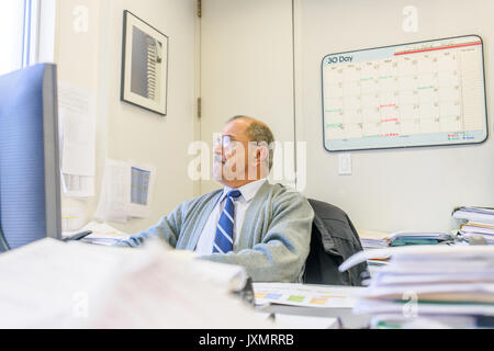 Male office worker using desktop computer at office desk Stock Photo