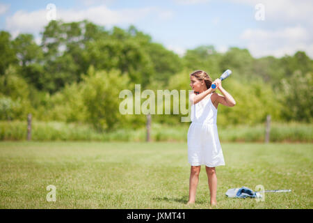 Girl playing baseball on field Stock Photo