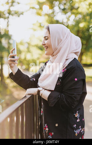 Young woman wearing hijab taking selfie smiling Stock Photo