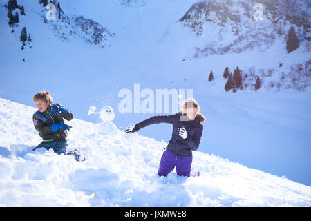 Siblings having snow ball fight, Hintertux, Tirol, Austria Stock Photo