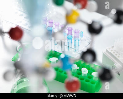 View through molecular model onto eppendorf tubes which are being used to test a sample in the laboratory Stock Photo