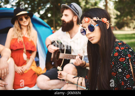 Young boho adults playing acoustic guitar at festival Stock Photo