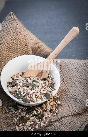 Selection of seeds in bowl with wooden spoon, close-up Stock Photo