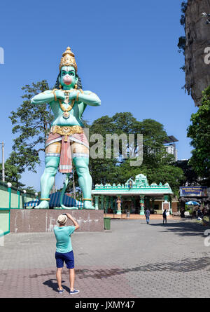 Kuala Lumpur, Malaysia - February 16, 2016 : tourist taking a photo of a huge statue of Lord Hanuman, a hindu deity, at Batu Caves complex Stock Photo