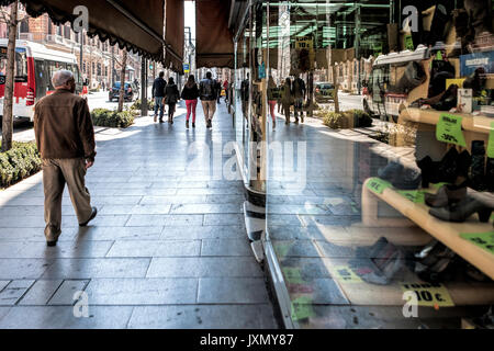People walking on Gran Via street and reflected in the shopwindow of the old shoe shop La Cordobesa, Granada, Spain Stock Photo