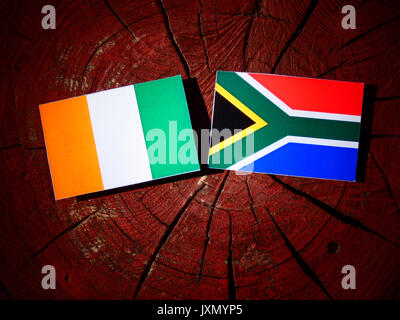 Ivory Coast flag with South African flag on a tree stump isolated Stock Photo