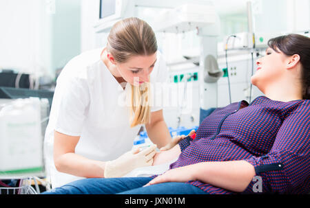 Nurse applying access at upper arm of patient Stock Photo