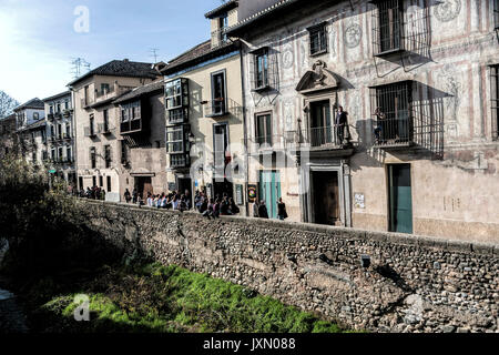 Granada, SPAIN - 16 february 2013: People leaned out and the balconies of a nineteenth century facade at the feet of the river Darro, Granada, Andalus Stock Photo