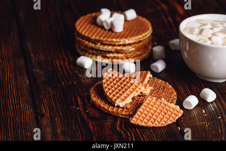 Syrup Waffles with Broken One with White Cup of Cocoa with Marshmallow and Waffle Stack. Copy Space on the Left. Stock Photo