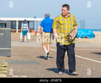 Casually dressed middle aged man walking along a path in Summer wearing sandals. Stock Photo