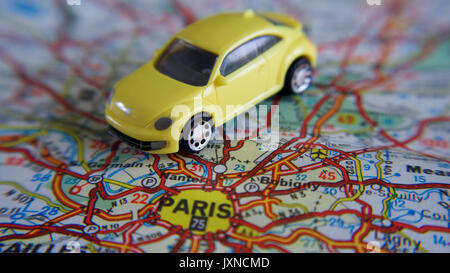 Road trip, bright yellow toy car on a road map Stock Photo
