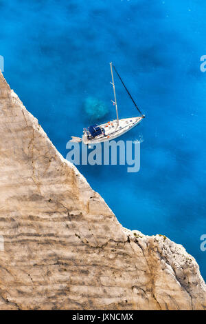 White luxury yacht against azure sea with swimming people Stock Photo