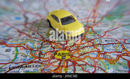 Road trip, bright yellow toy car on a road map Stock Photo