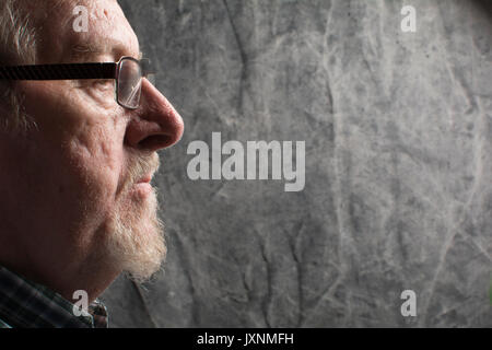 profile of an older man with a beard and spectacles, in vacant or pensive mood Stock Photo