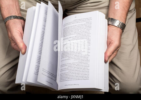 A man flicking through the pages of a book. Stock Photo