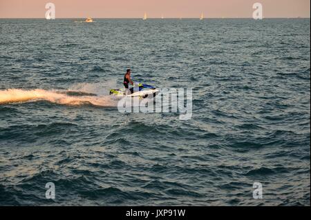 Man piloting a watercraft on Lake Michigan just outside Chicago's Diversey Harbor. Chicago, Illinois, USA. Stock Photo