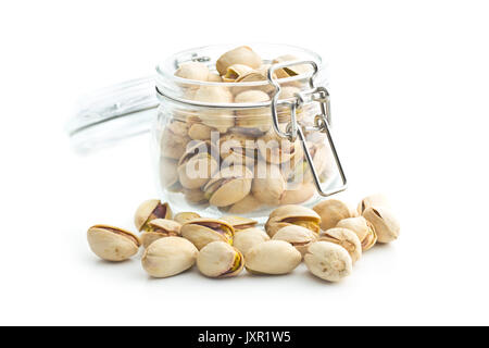 Pistachio nuts in jar isolated on white background. Glass jar with pistachio nuts. Stock Photo