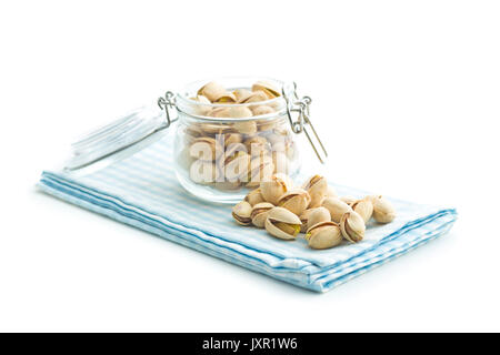 Pistachio nuts in jar isolated on white background. Glass jar with pistachio nuts. Stock Photo