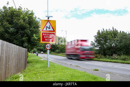 A Lorry passes a Reduce speed sign in High Wycombe, England on 16 August 2017. Photo by Andy Rowland. Stock Photo