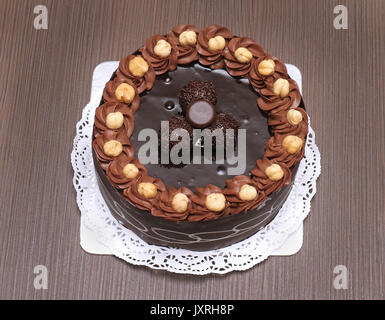 Tasty chocolate cake with hazelnuts on white plate Stock Photo