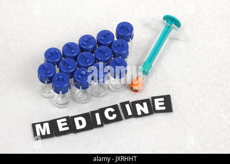 Bunch of vials with medicine and syringe on blotch paper Stock Photo