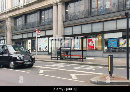LONDON, UK - March 26: Whiteleys shopping center bus stop with people sitting on the bench while waiting  in London, UK - March 26, 2016; Public bus s Stock Photo