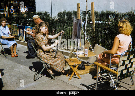 Young woman having her portrait drawn by a female street artist in Greenwich Village, New York, in September 1958. Image shows fashion of thge 1950s period. Stock Photo