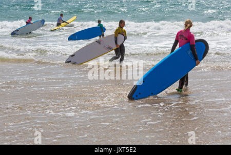 Boscombe, Bournemouth, Dorset, UK. 17th August, 2017. UK weather: sunny spells at Boscombe beach. Surfers enjoy the waves at the seaside carrying their surf boards into the sea. Credit: Carolyn Jenkins/Alamy Live News Stock Photo