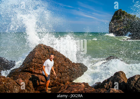 Man escaping incoming big wave on the coast in Thailand Stock Photo