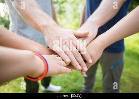 Closeup Of Friends Stacking Hands In Forest Stock Photo