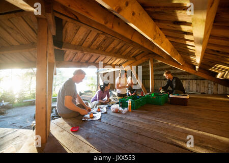 Business People Preparing Food In Shed At Forest Stock Photo